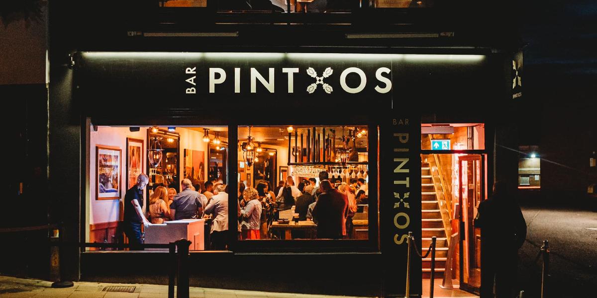 View inside Bar Pintxos from street outside during evening.