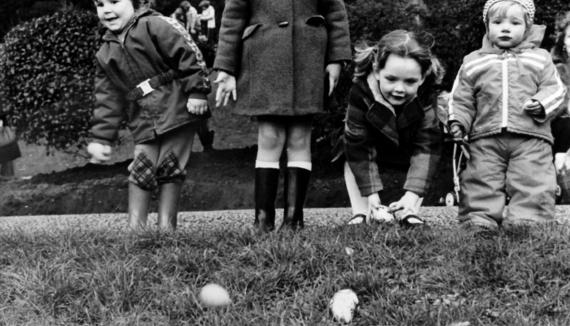 Children stood on Avenham Park hill rolling eggs in black and white.