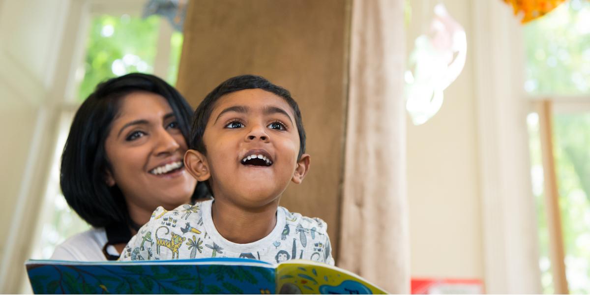 Woman and son reading library book together.