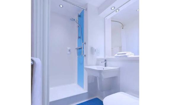 Travelodge Preston Chorley blue and ensuite white bathroom.