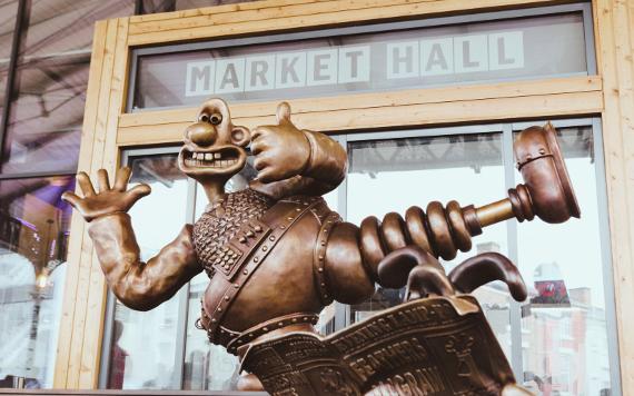 Close up of Gromit statue holding his thumb up.